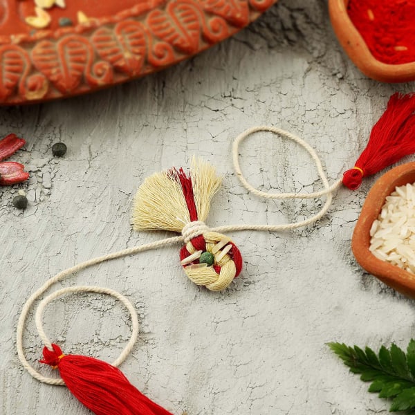 Red And Beige Potli Seed Rakhi