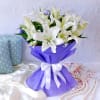 Buy White Lilies Arrangement in Blue Wrapping with Black Forest Cake (Half Kg)