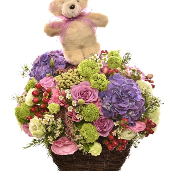 Arrangement of cut flowers with Teddy Bear