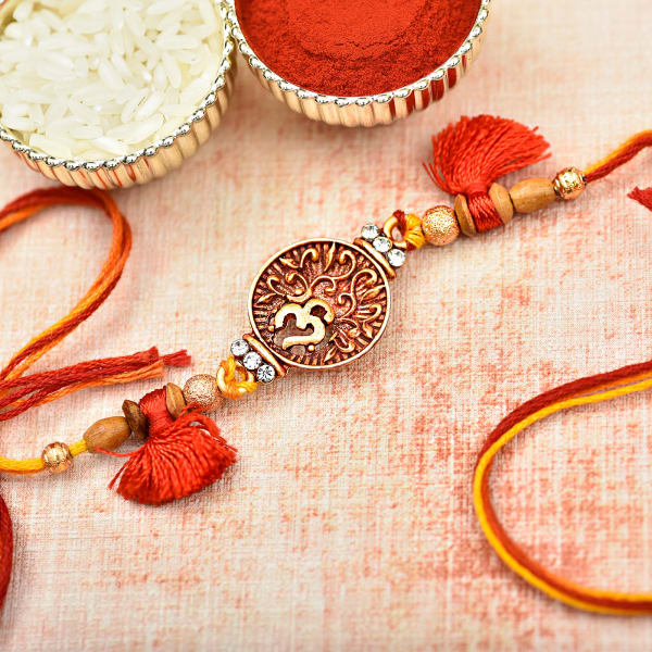 Unique Metallic Om Dial Rakhi Decorated with Wooden Beads & Red Thread