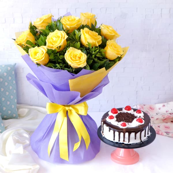 Yellow Roses Arranged in Blue Wrapping with Black Forest Cake (Half Kg)