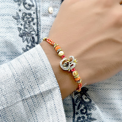 Traditional Om with Shivling Rakhi Curated by Gold & Red Beads